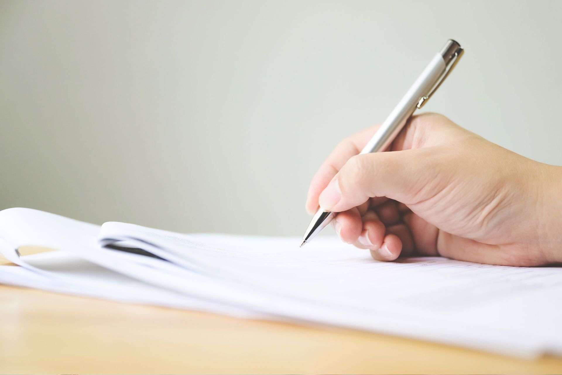 Una persona está escribiendo en un trozo de papel con una lupa.