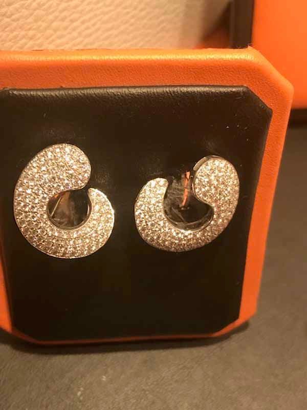 Un par de pendientes están encima de una caja naranja.