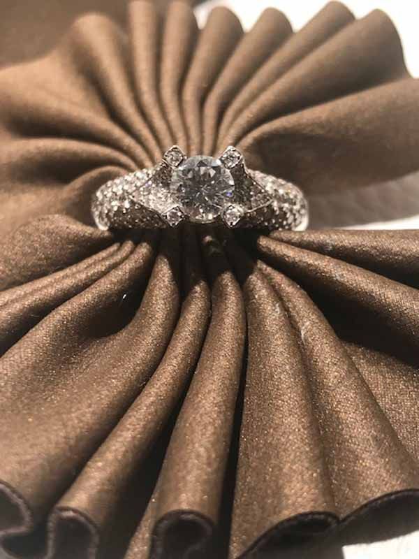 Un anillo de diamantes reposa sobre una servilleta marrón.