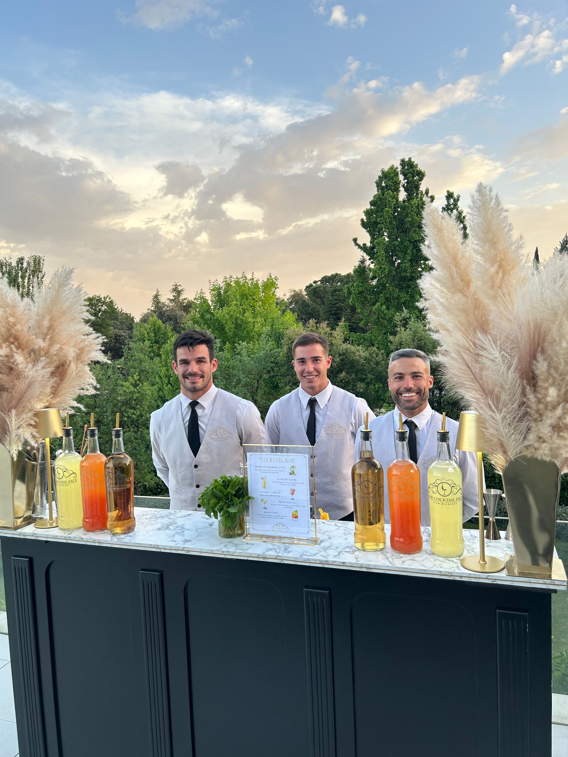 Cuatro cócteles magenta adornados con arándanos y flores blancas en una bandeja.