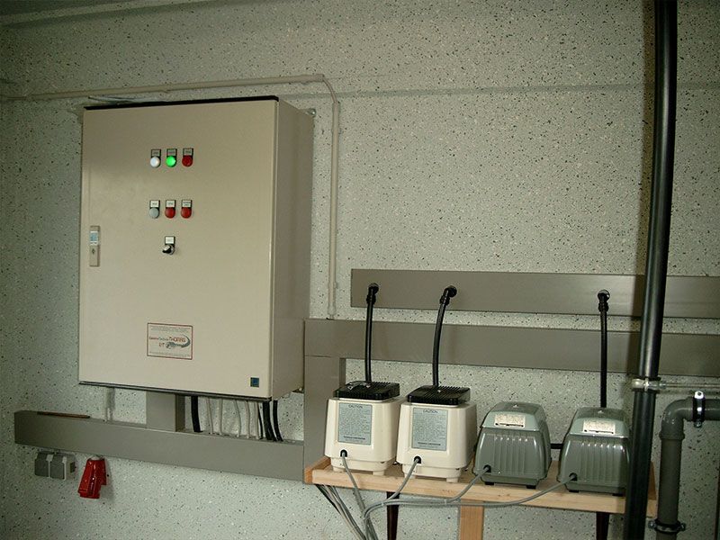 Eine Reihe von Mikrofonen steht auf einem Regal neben einem Bedienfeld