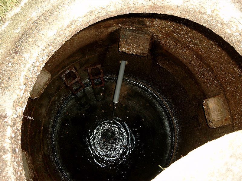 Ein Schachtdeckel, aus dem ein Rohr herauskommt