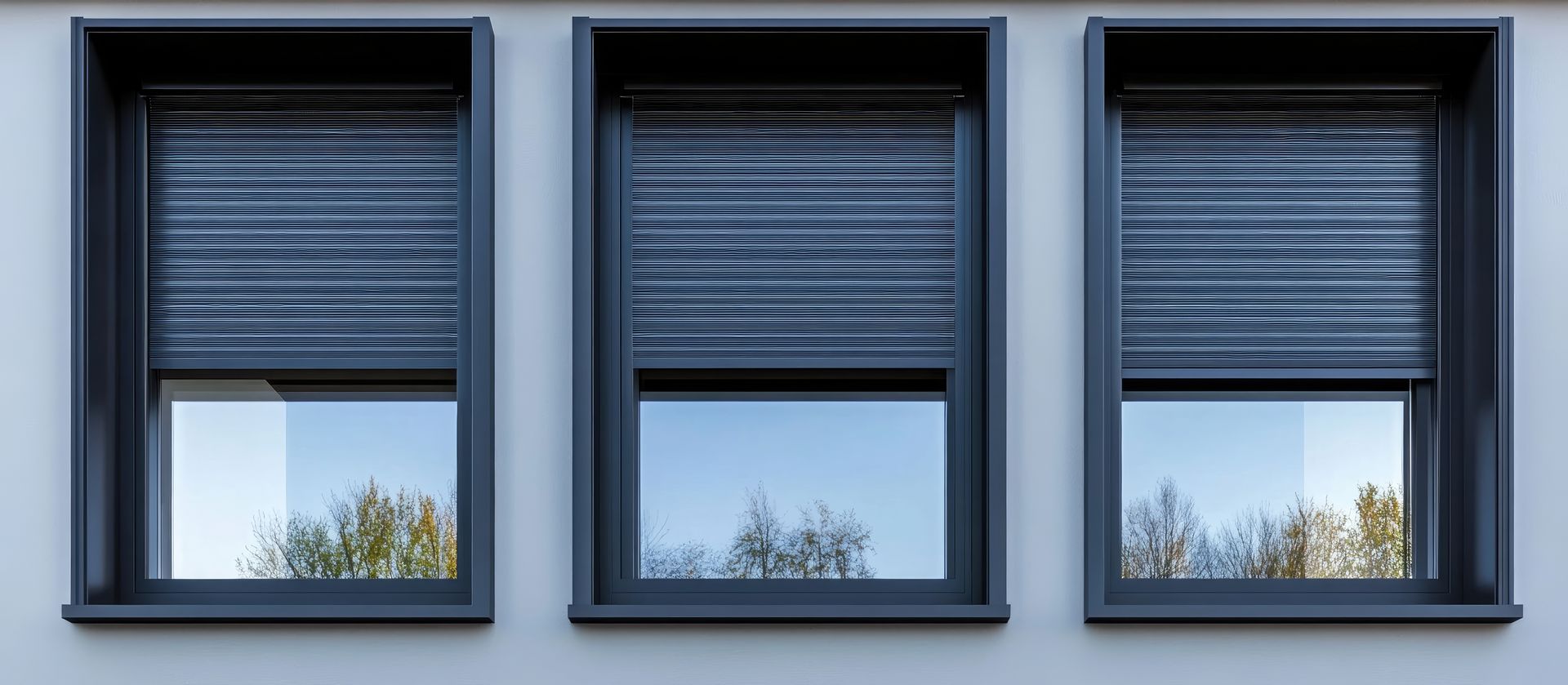 Trois volets bleu-gris sur la façade claire d'un bâtiment.