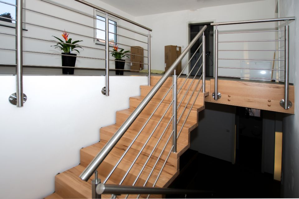 Breite Holztreppe mit Metallgeländer