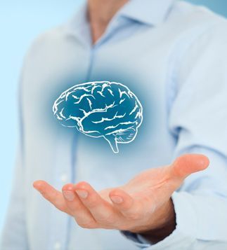 Un hombre sostiene un dibujo de un cerebro en su mano.
