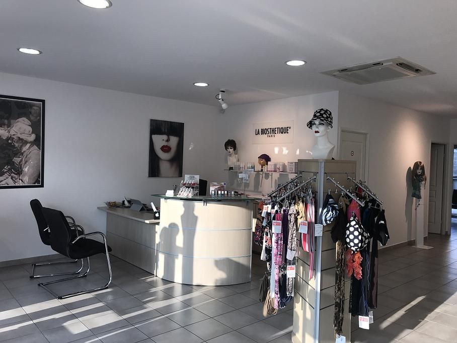 Intérieur d'un magasin de détail avec un comptoir, des présentoirs d'accessoires et une affiche représentant une femme.