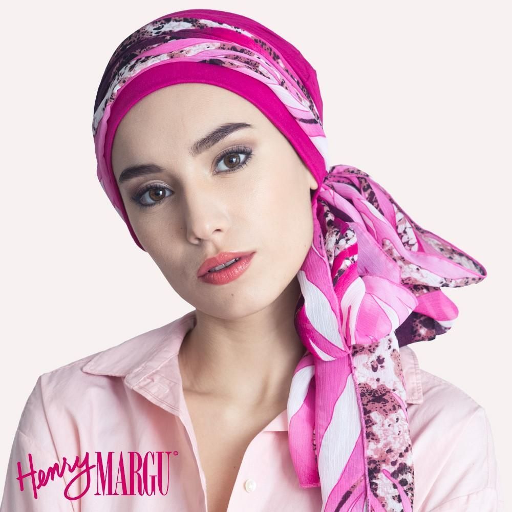 Femme portant un foulard rose à motifs ; chemise rose clair.
