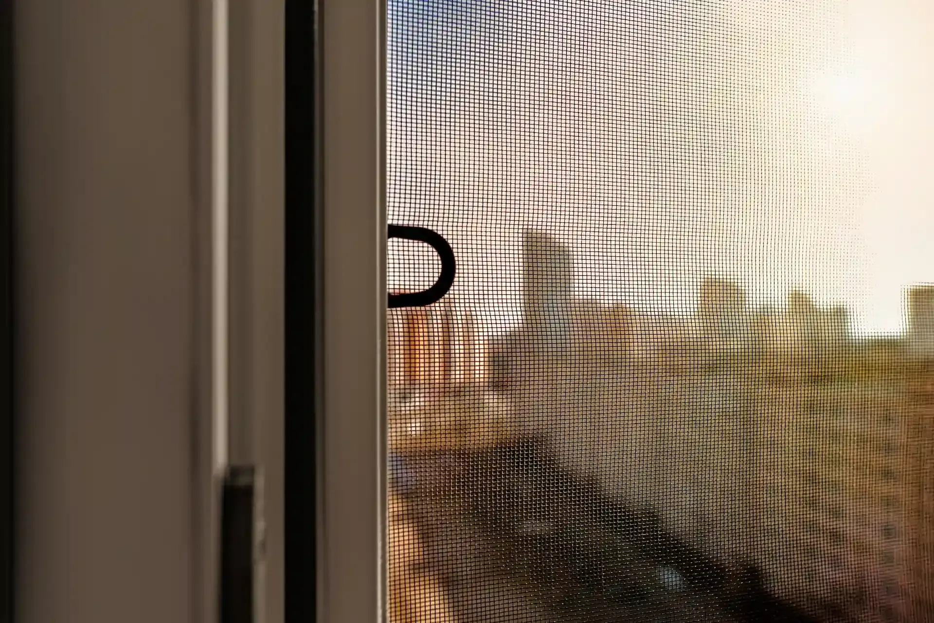 Persona en un baño aplicando sellador a una puerta de ducha de vidrio.