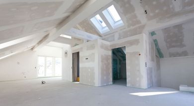 Ein leerer Raum mit Trockenbauwänden und einem Oberlicht in der Decke.