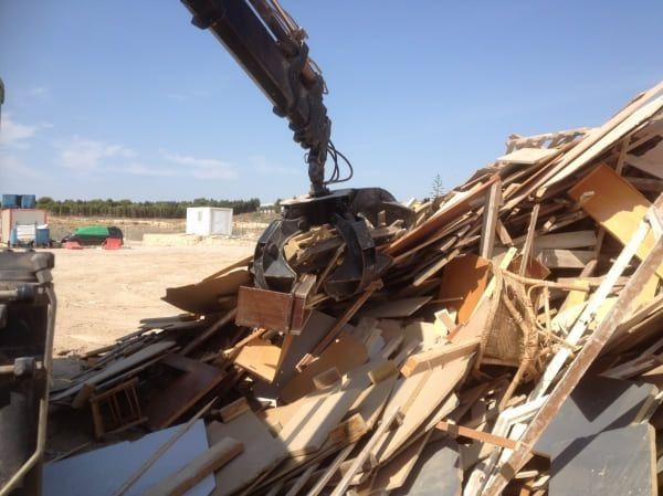 Una pila de madera está siendo levantada por una grúa