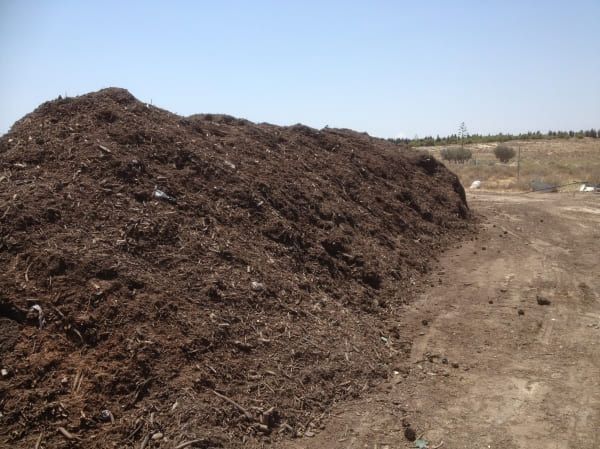 Un gran montón de tierra se encuentra encima de un camino de tierra.