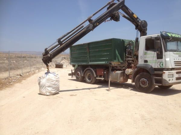 Un camión con una grúa acoplada y la letra c en el frente.