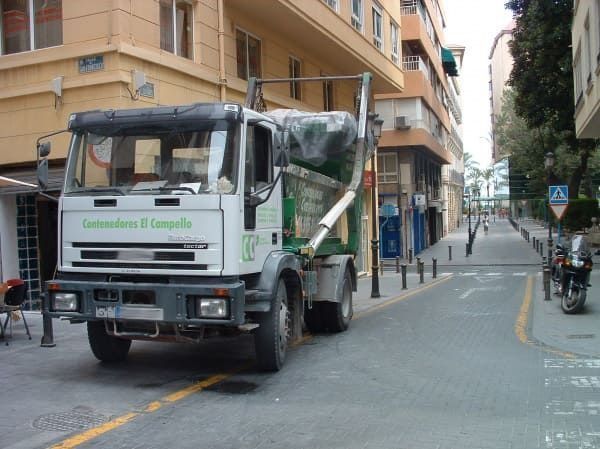 Un camión verde y blanco está estacionado al costado de la carretera.