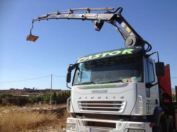 Una grúa está unida a la parte delantera de un camión que dice pastor