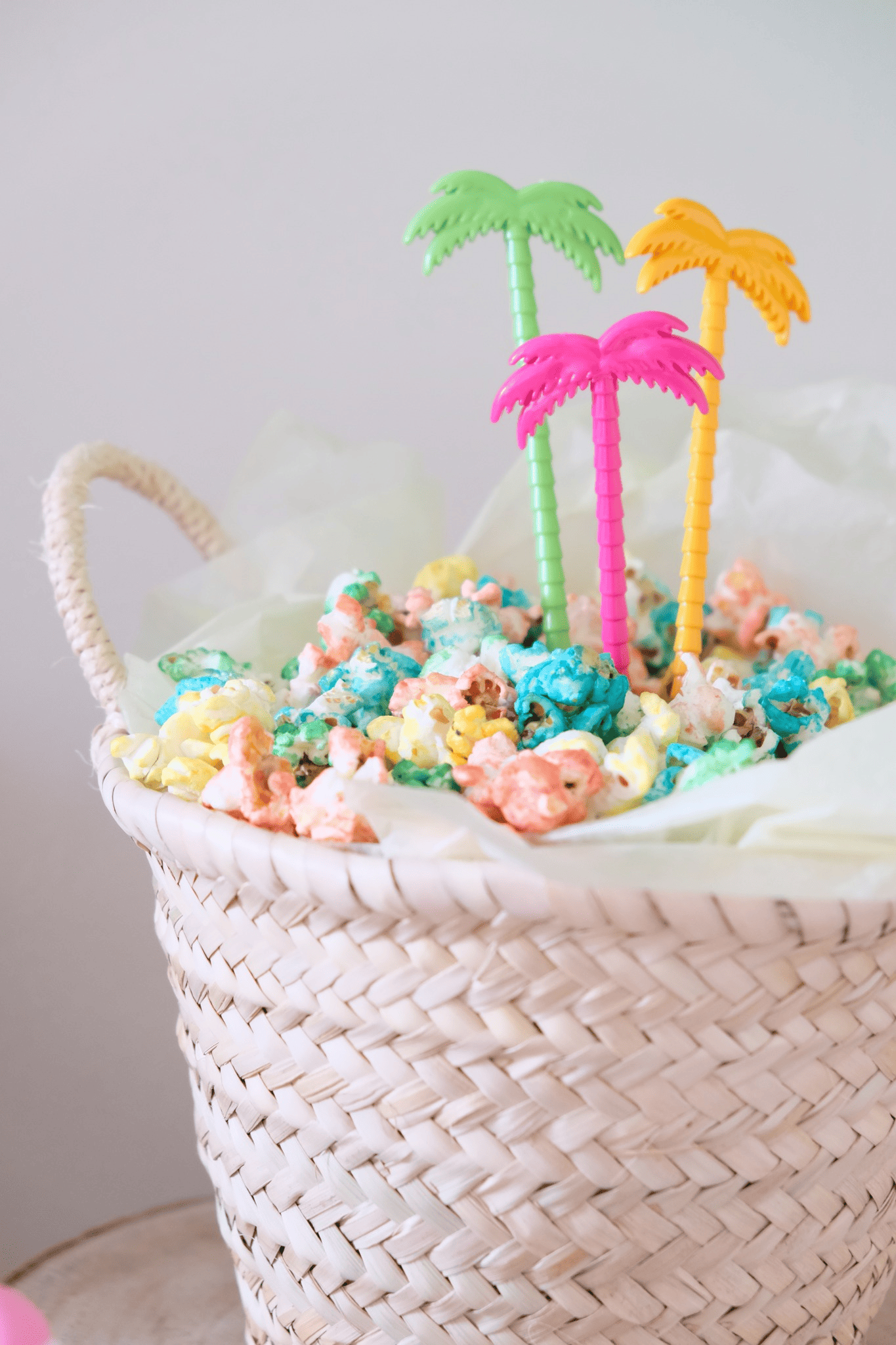 Un canasta con palomitas de colores y palmeras de colores
