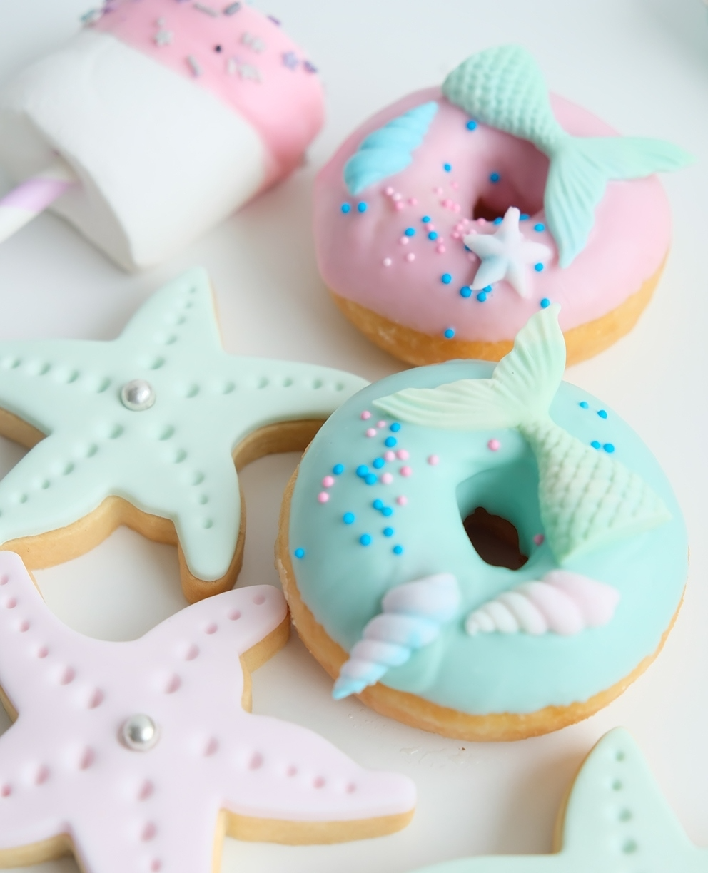 Una dona con una cola de sirena y una estrella de mar encima.