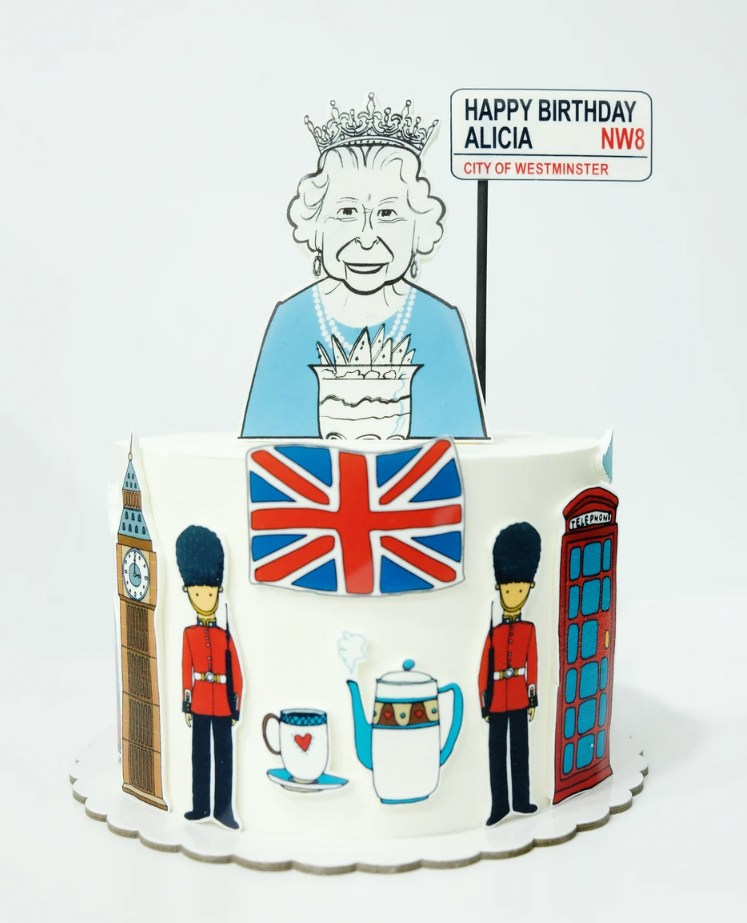 Un pastel con la reina encima y un cartel que dice feliz cumpleaños alicia