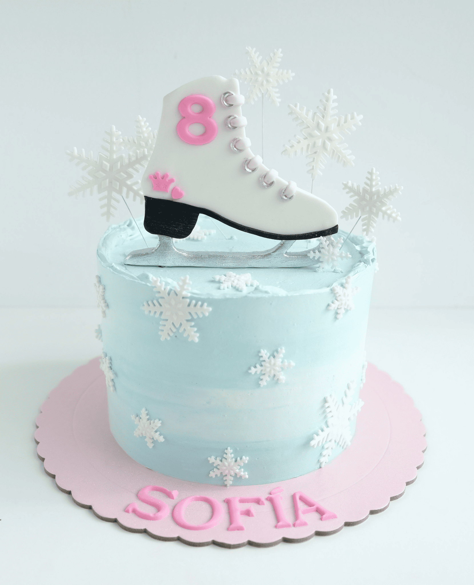 Un pastel de cumpleaños para Sofía con un patín de hielo encima.
