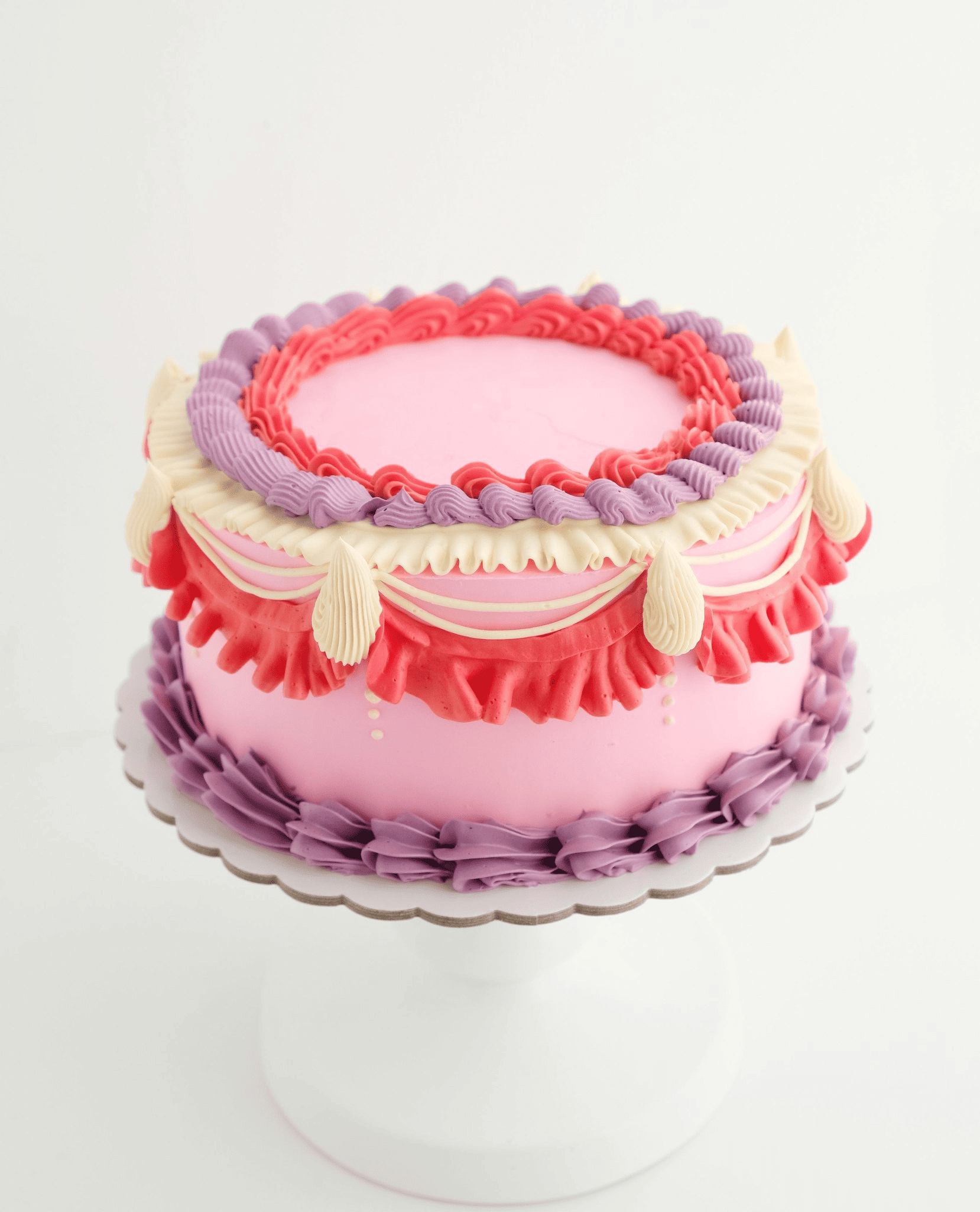 Un pastel rosa y morado en un plato blanco.