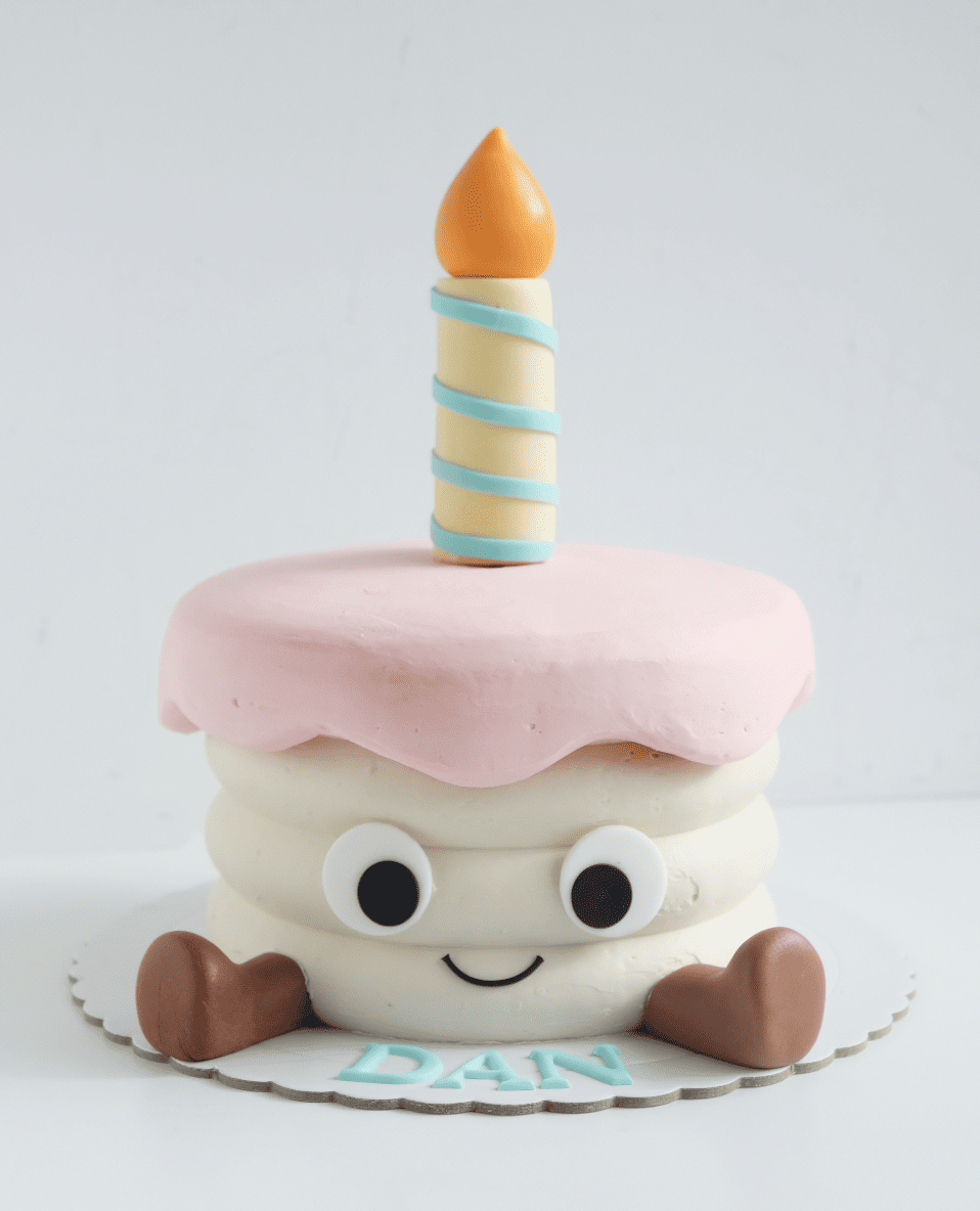 Un pastel de cumpleaños con una vela y el nombre Dan en él.