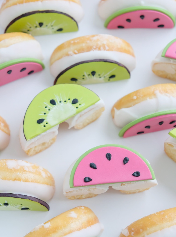 Un montón de donas con rodajas de sandía y kiwi encima.