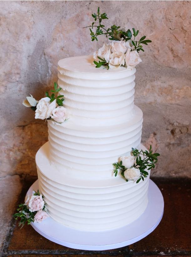 Un pastel de bodas blanco con flores encima.