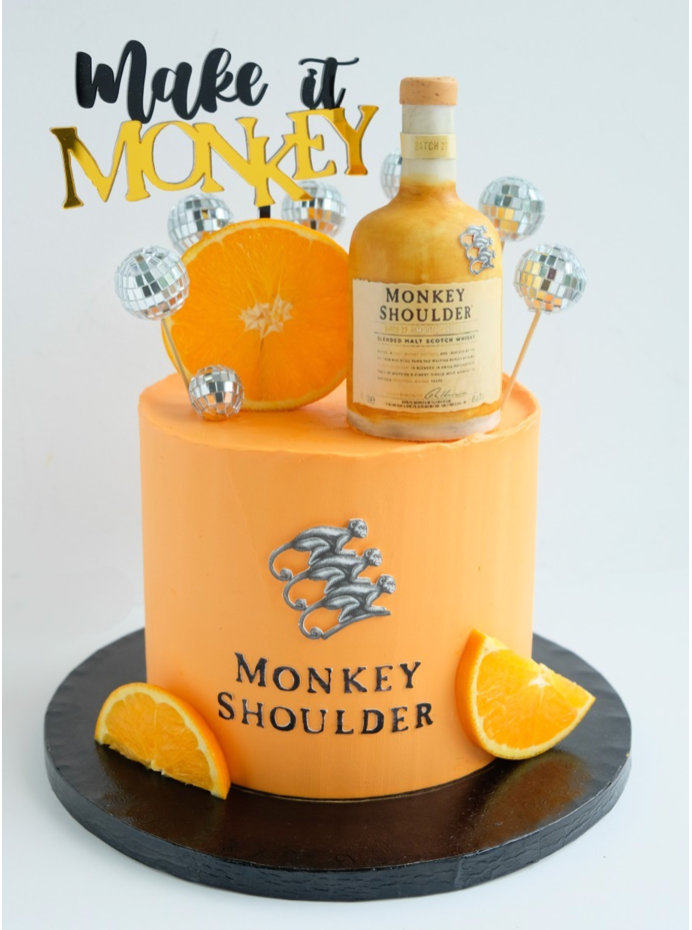 Un pastel naranja que dice make it monkey 