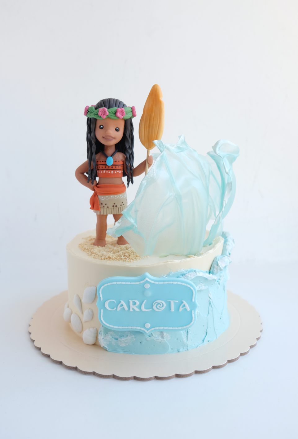 Un pastel con una figura de Moana encima.