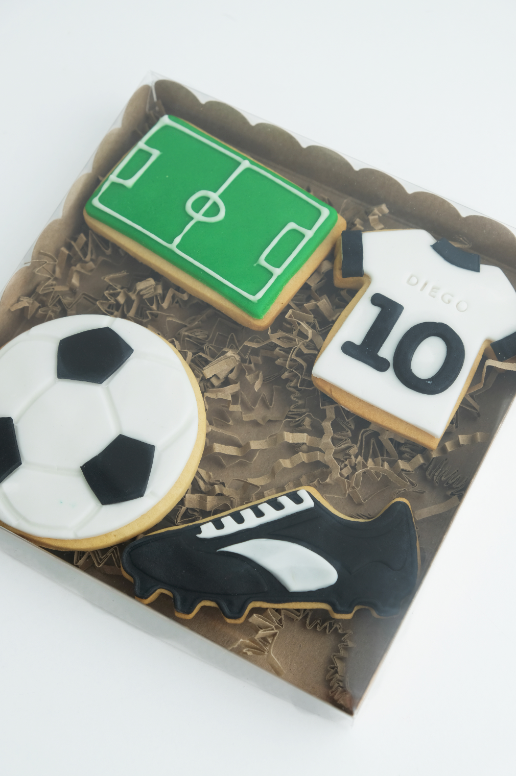 Una caja de galletas de fútbol con un balón de fútbol, ​​un zapato de fútbol y una camiseta con el número 10.