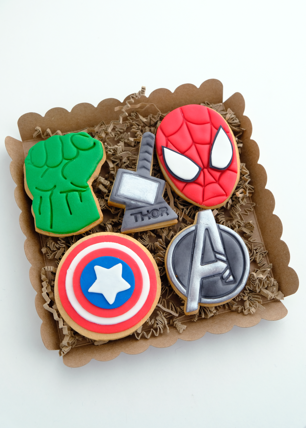 Una caja llena de galletas de los Vengadores, incluidos el Capitán América, Hulk, Spiderman y Thor.