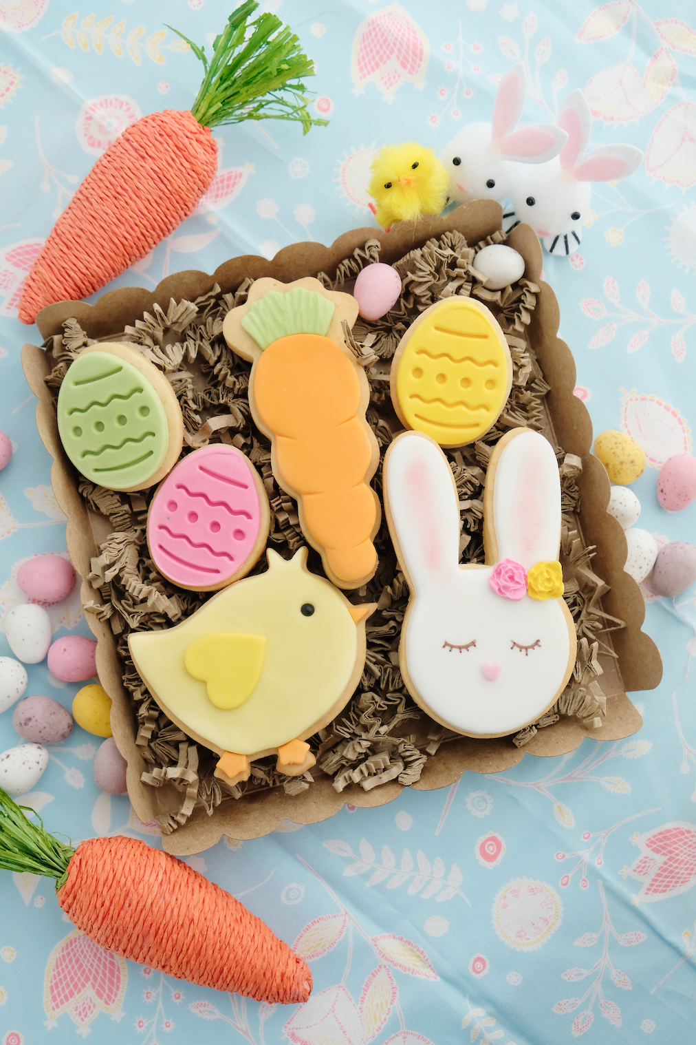 Una caja llena de galletas y huevos de Pascua sobre una mesa.