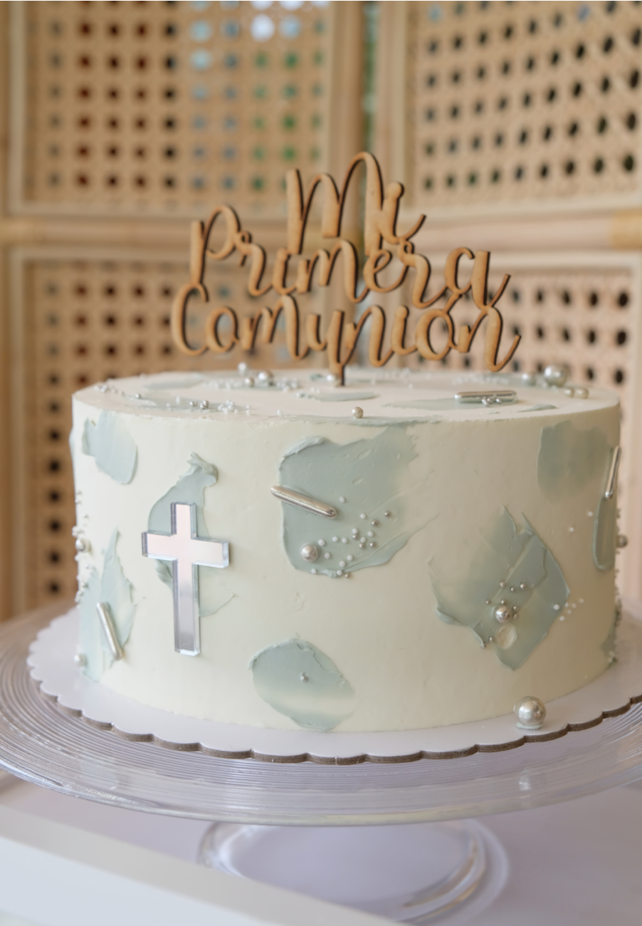 Un pastel con una cruz encima está sobre una mesa.