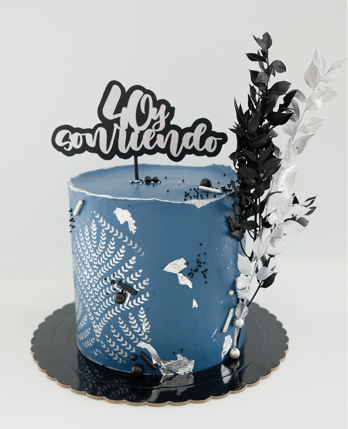 Un pastel azul con un adorno que dice 40.