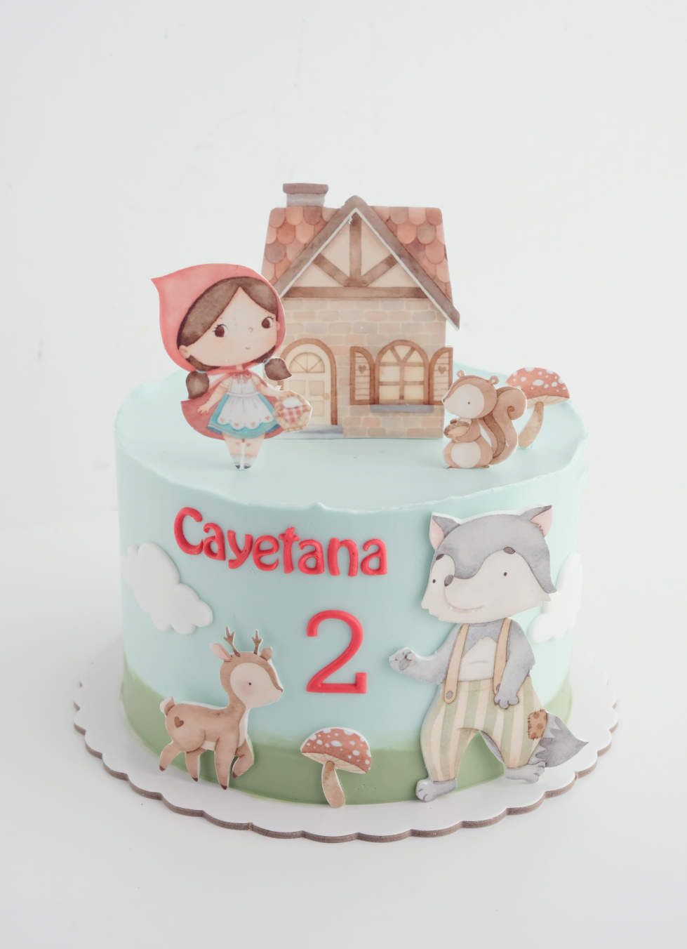 Un pastel con Caperucita Roja y un lobo encima.