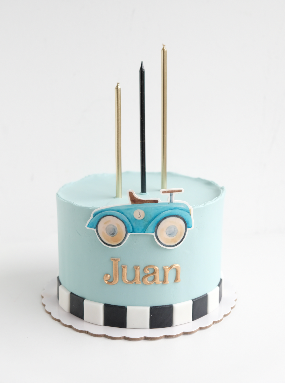 Un pastel de cumpleaños para Juan con un coche azul encima.