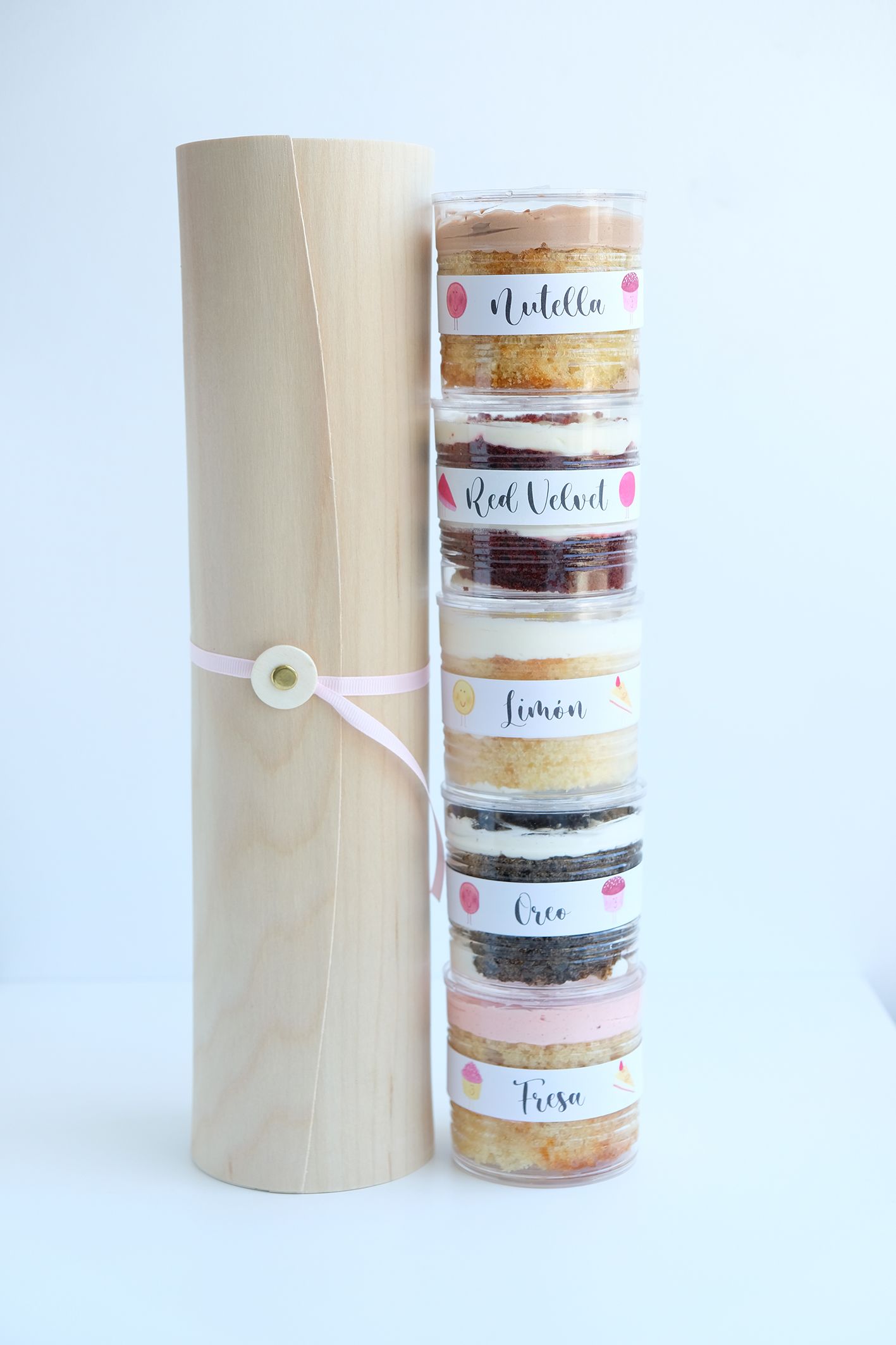 Una pila de frascos llenos de diferentes tipos de alimentos junto a un rollo de papel marrón.