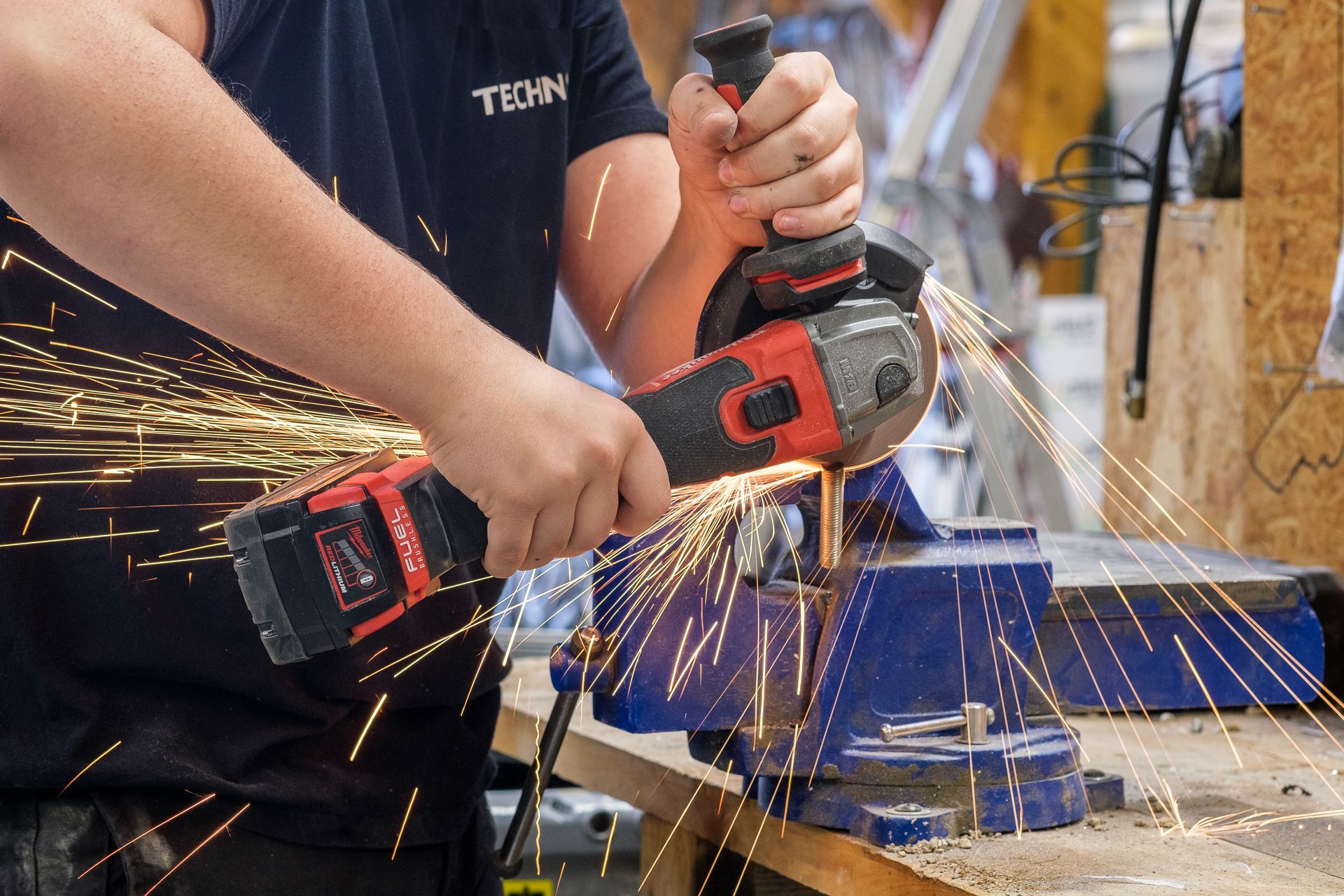 Professionnel dans un atelier en train d'utiliser une scie circulaire produisant des étincelles