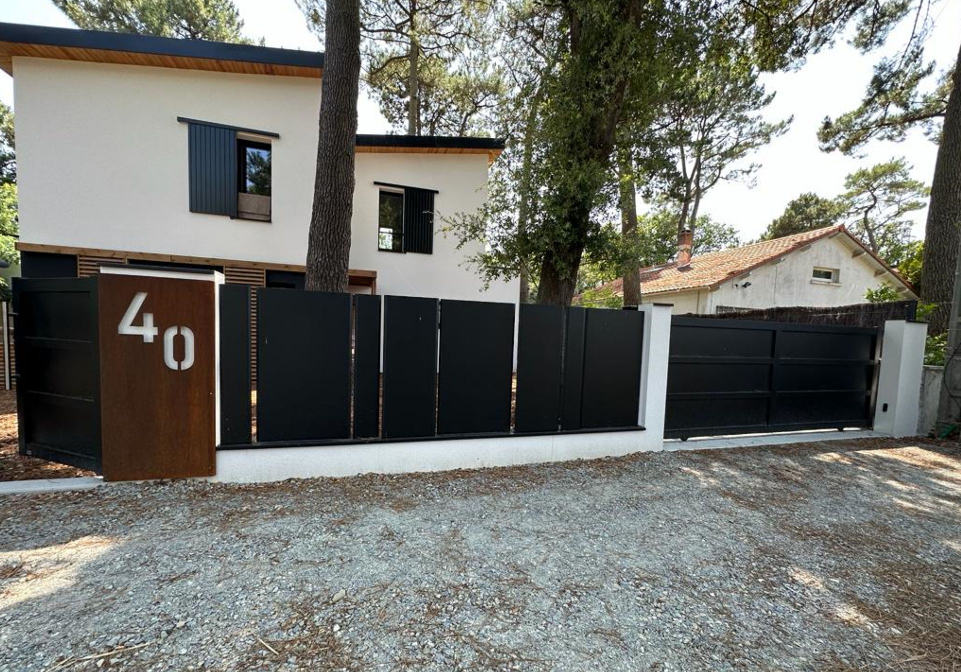 Clôture et portail de couleur noire mate d'une habitation portant le numéro 40