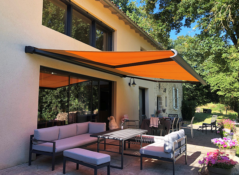 Store banne orangé ouvert sur une terrasse de maison