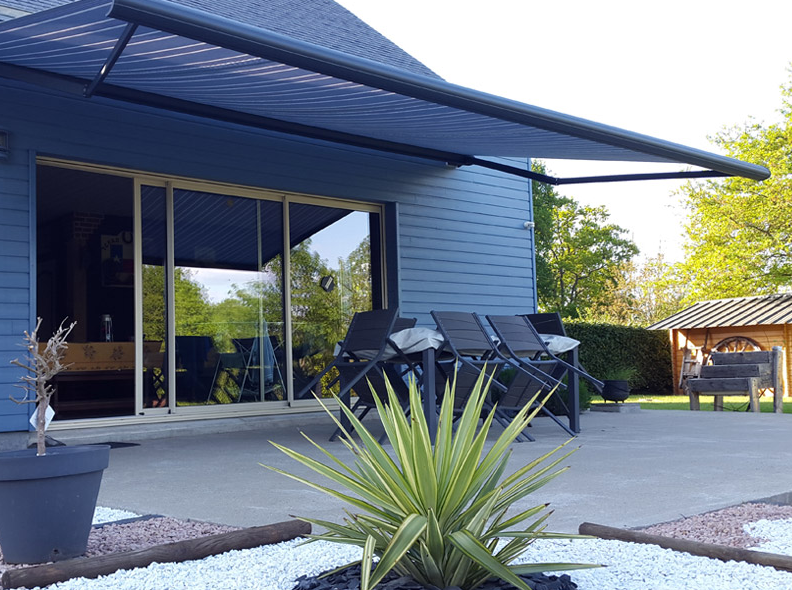 Store banne ouvert au-dessus d'une terrasse de maison