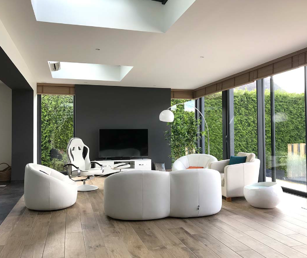 Intérieur de salon moderne avec de grandes baies vitrées et plusieurs canapés et fauteuils blancs