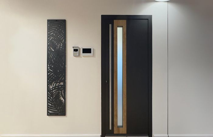 Porte d'entrée noire avec une poignée en barre de fer