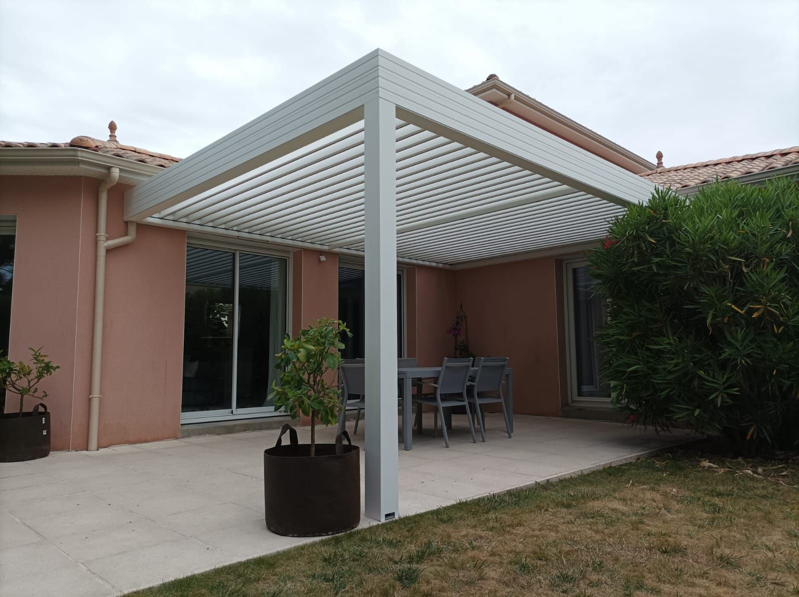 Pergola blanche au-dessus d'une terrasse en béton