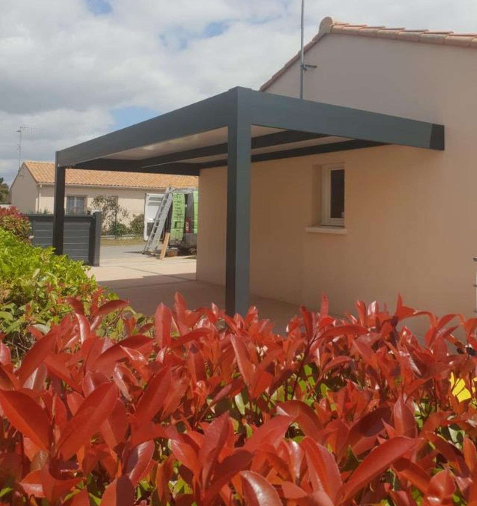 Carport avec poteaux déportés fixés sur un côté de maison 