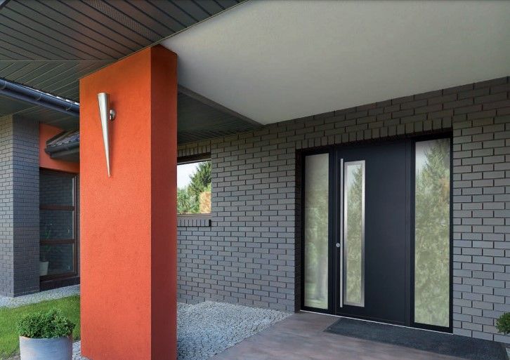 Porte d'entrée avec vitre d'un bâtiment devant un grand pilier orange