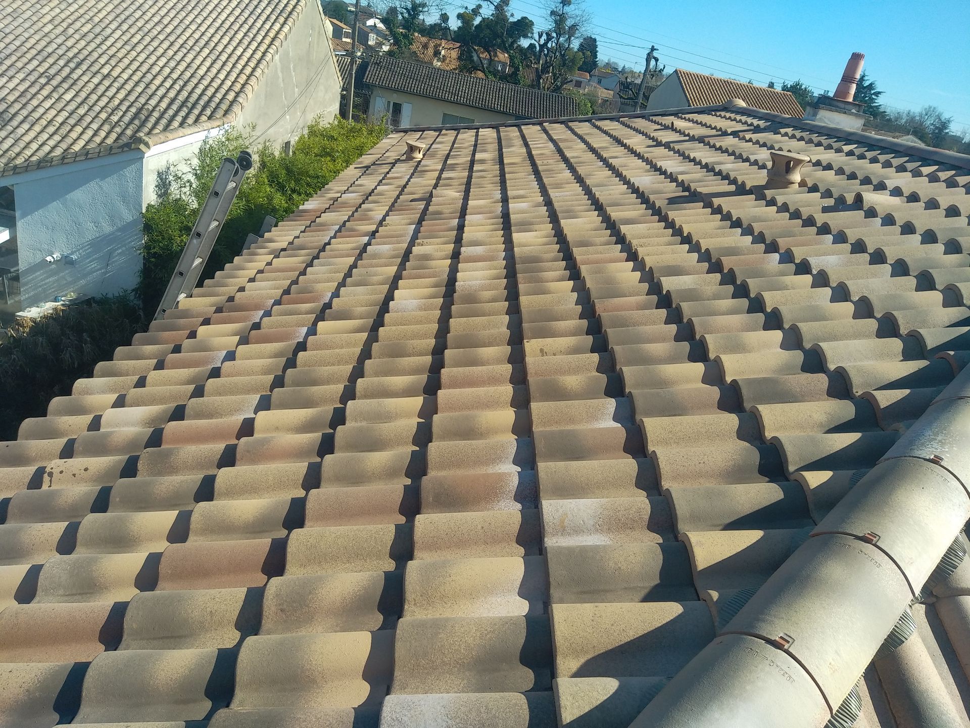 Toiture en tuiles beige avec des reflets blancs