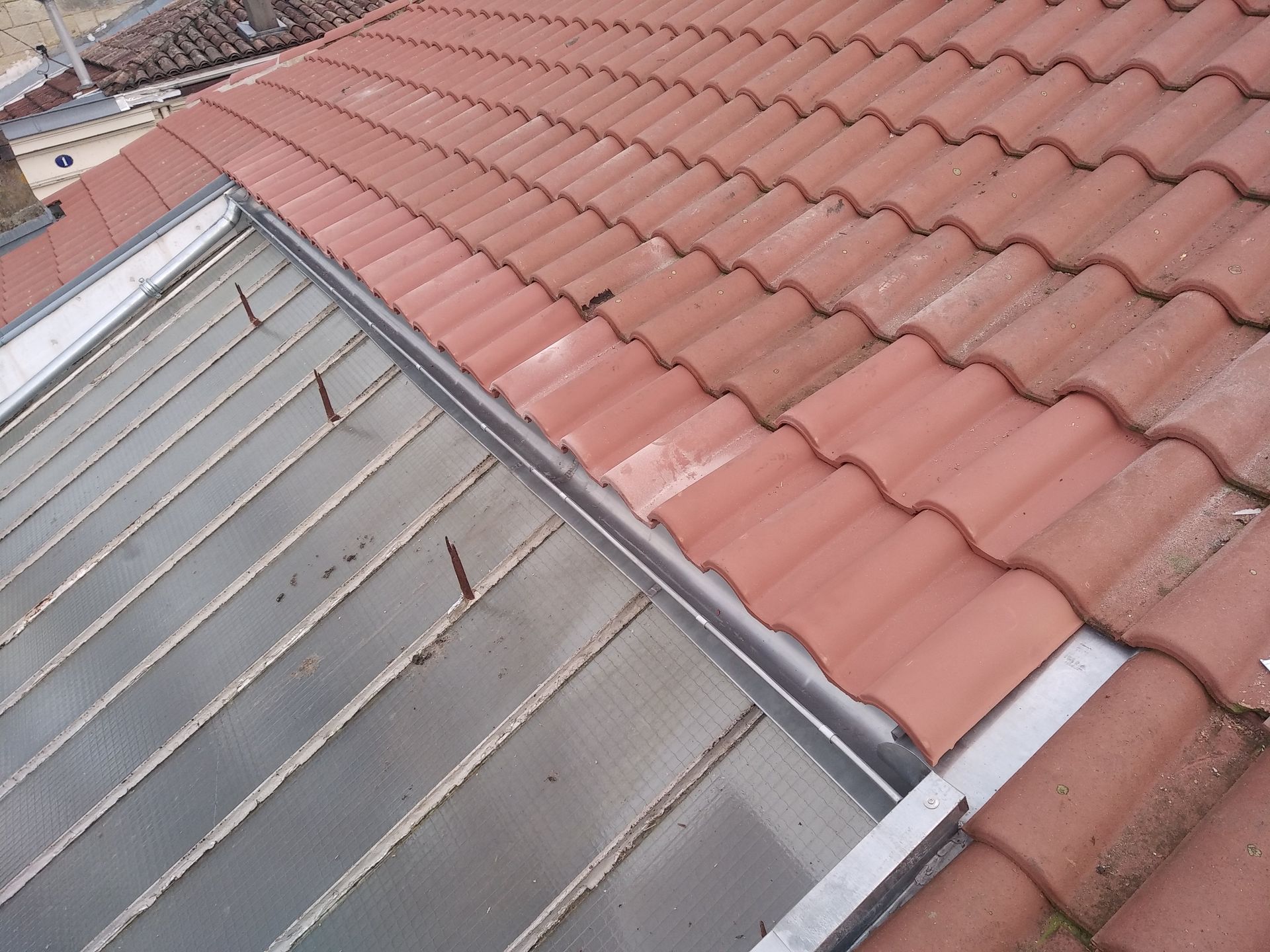 Travaux de zinguerie sur un toit en tuiles