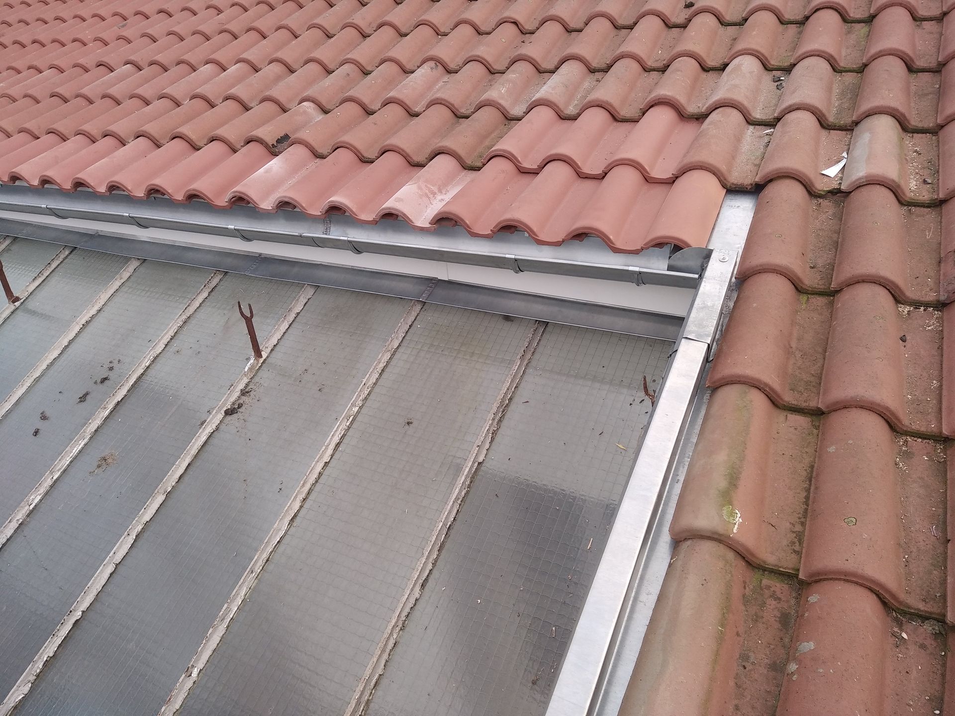 Pose de zingueries sur une toiture en tuiles