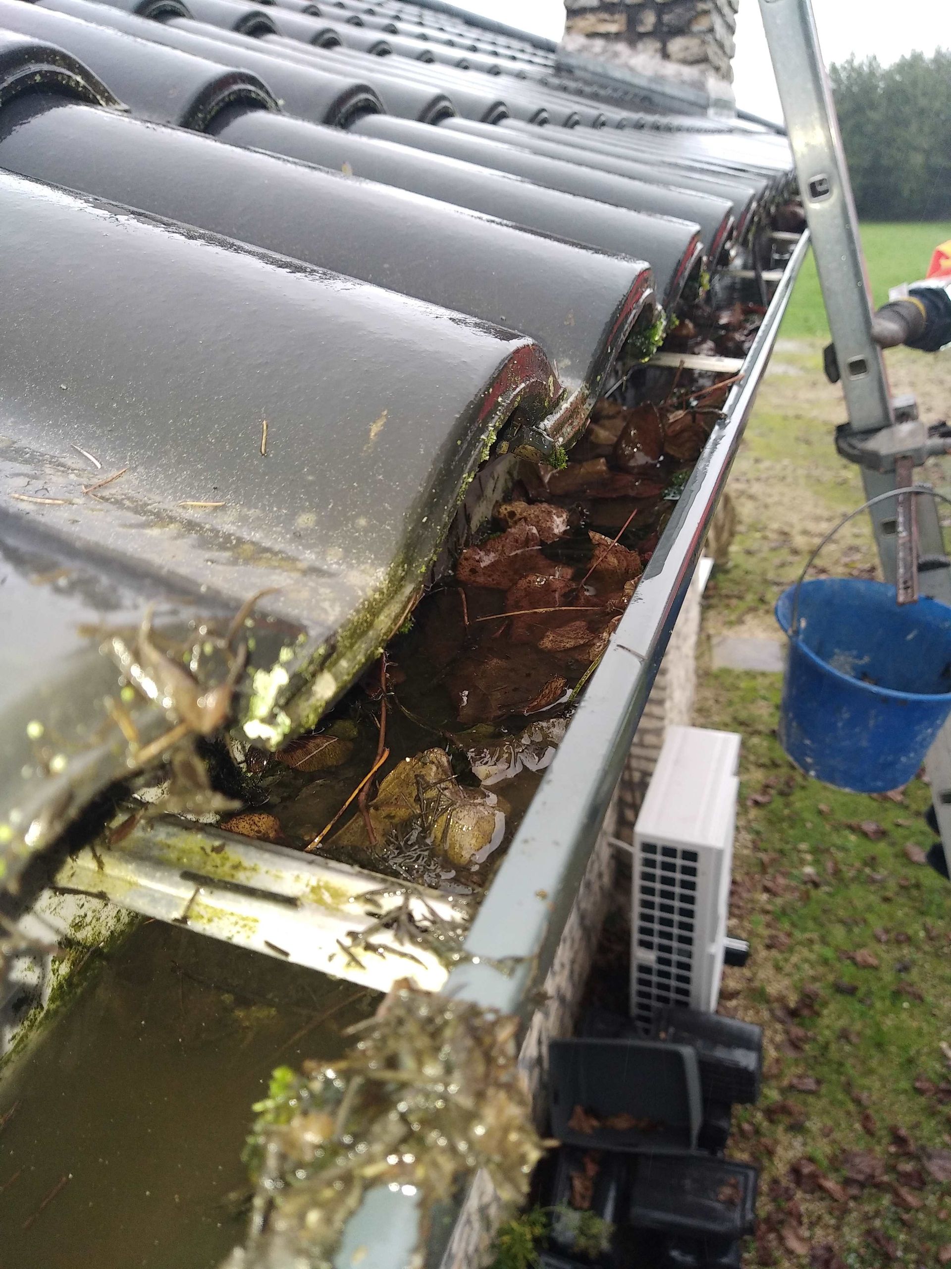 Nettoyage d'une gouttière encrassée