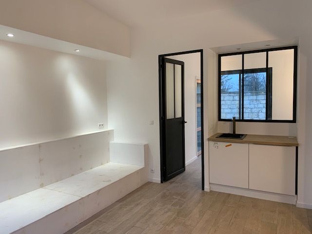 Pièce de vie rénovée aux murs blancs